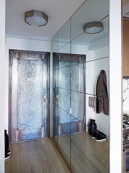 The mirrored entry hall sets a bright tone right off the bat. Samuel stripped off the old moldings on the door to get to the original zinc, then scraped it “about 17 times” to achieve this lustrous look.
